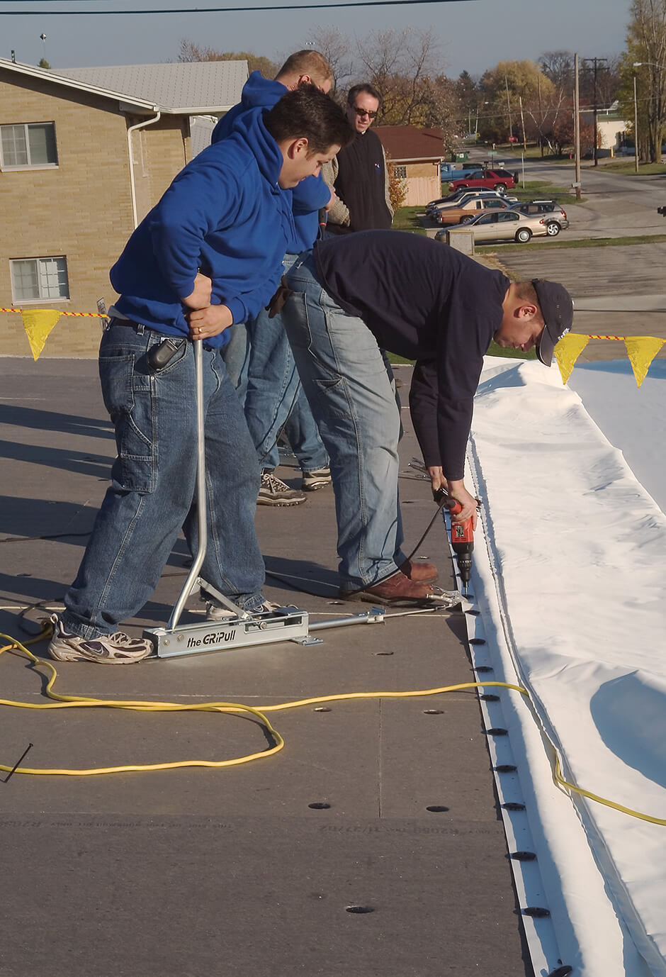 Crew installing a new single-ply commercial roofing system
